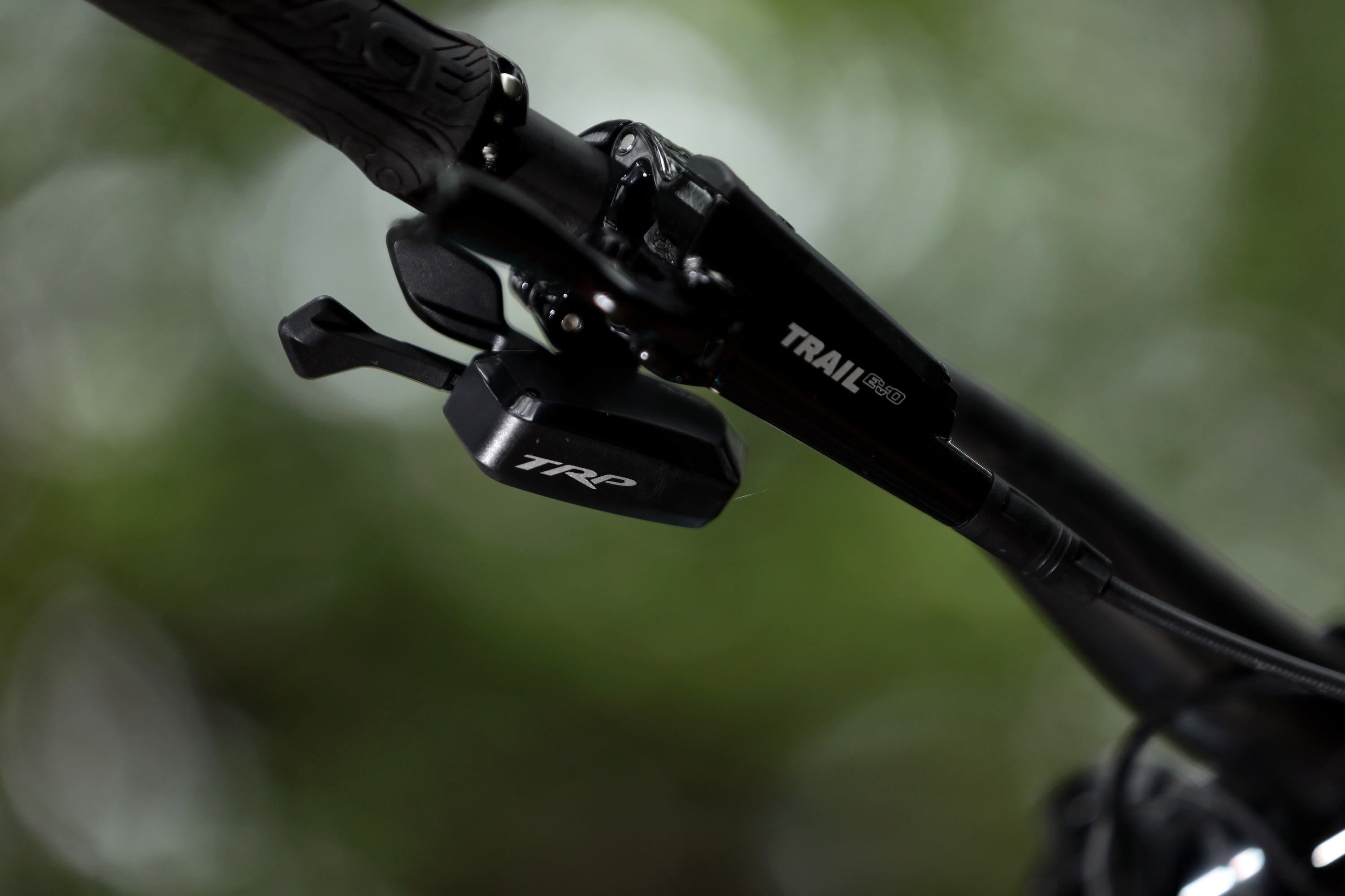 Close-up the CMD Swift Shift of the E.A.S.I drivetrain system on a bicycle handlebar with a blurred natural background