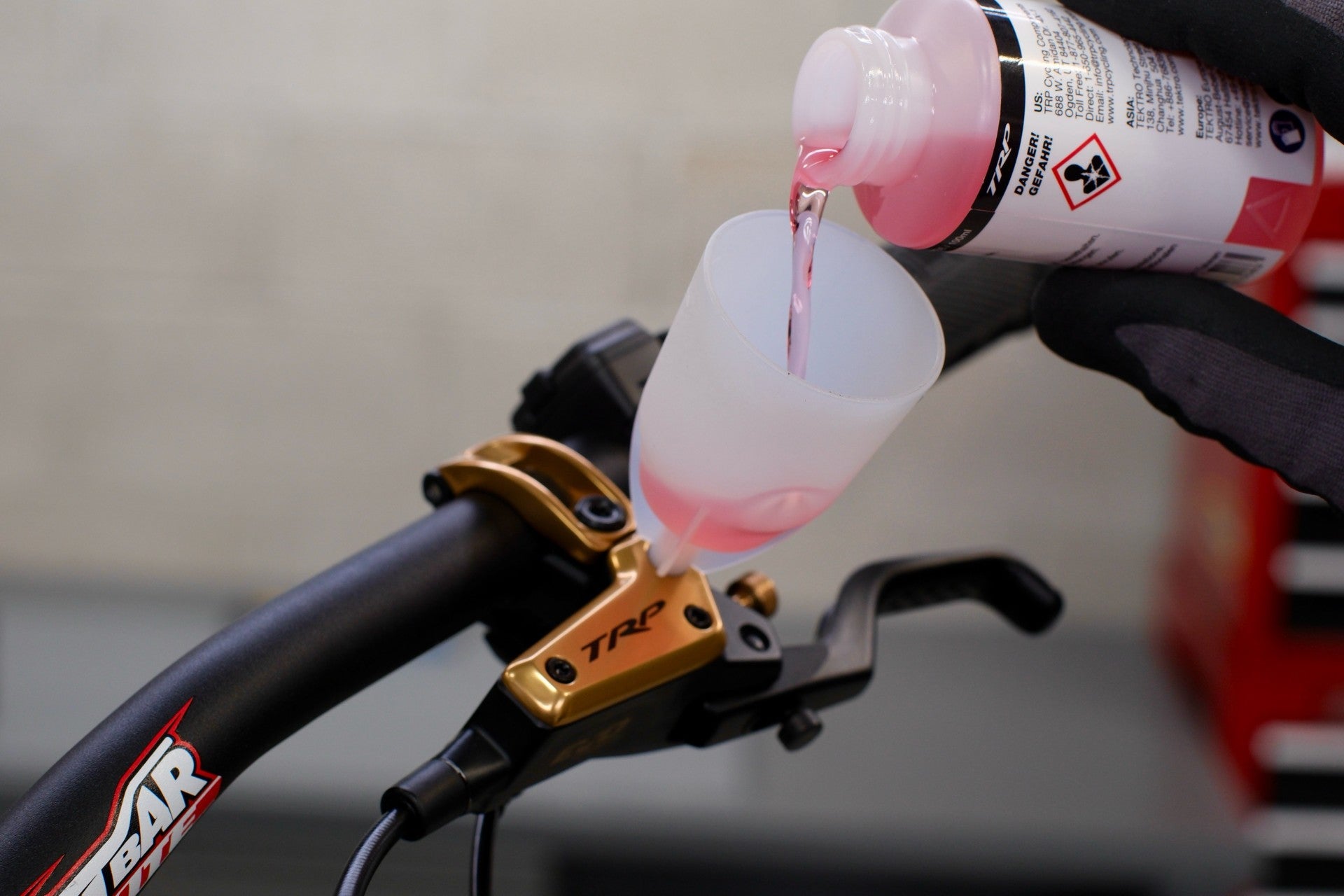 Bicycle brake lever with oil being poured into it, for bleeding.