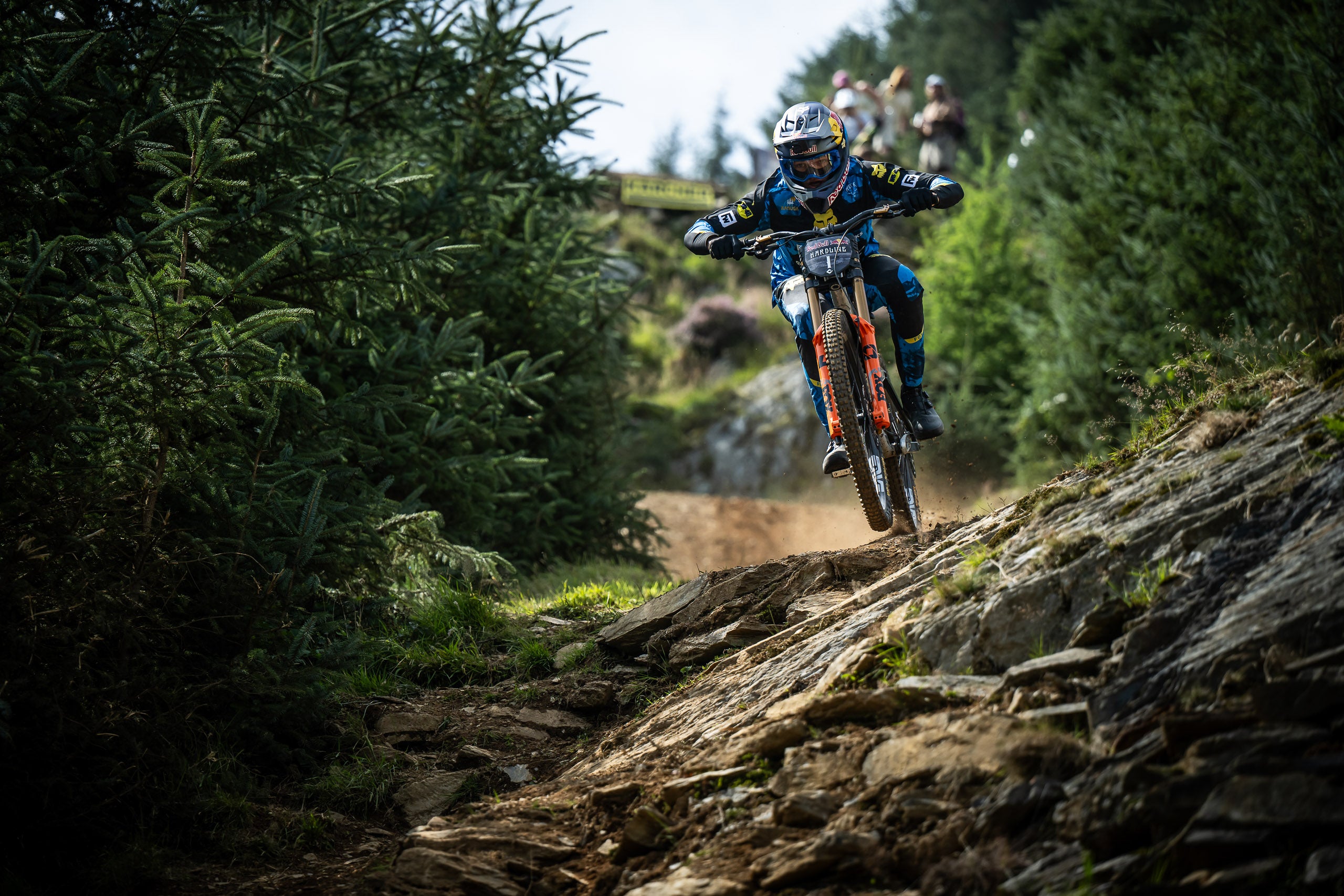 Team Member Asa riding a mountain bike on a rocky trail in a forest