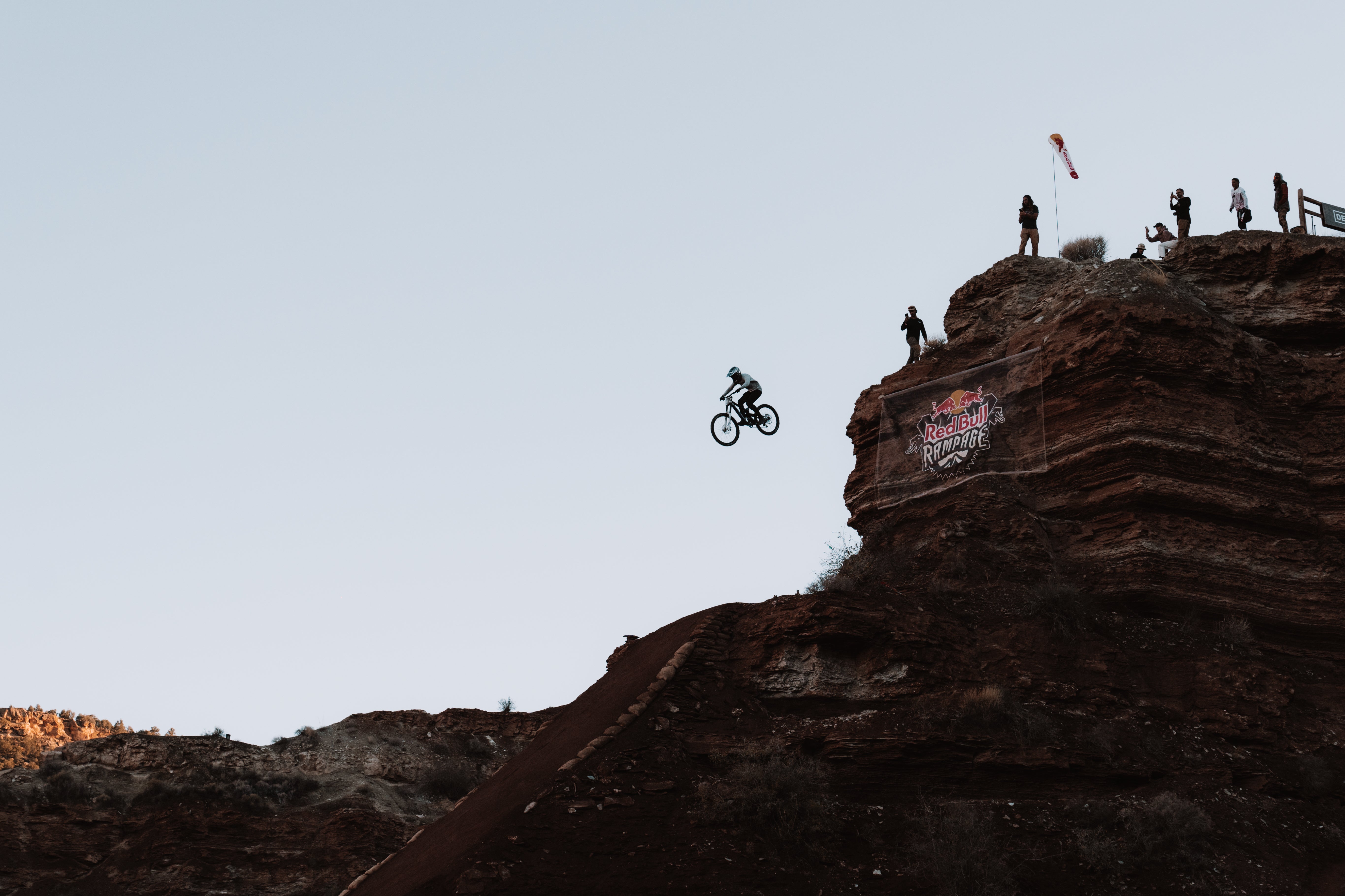 TRP team rider on a bike performing a stunt off a high cliff at Red Bull Rampage