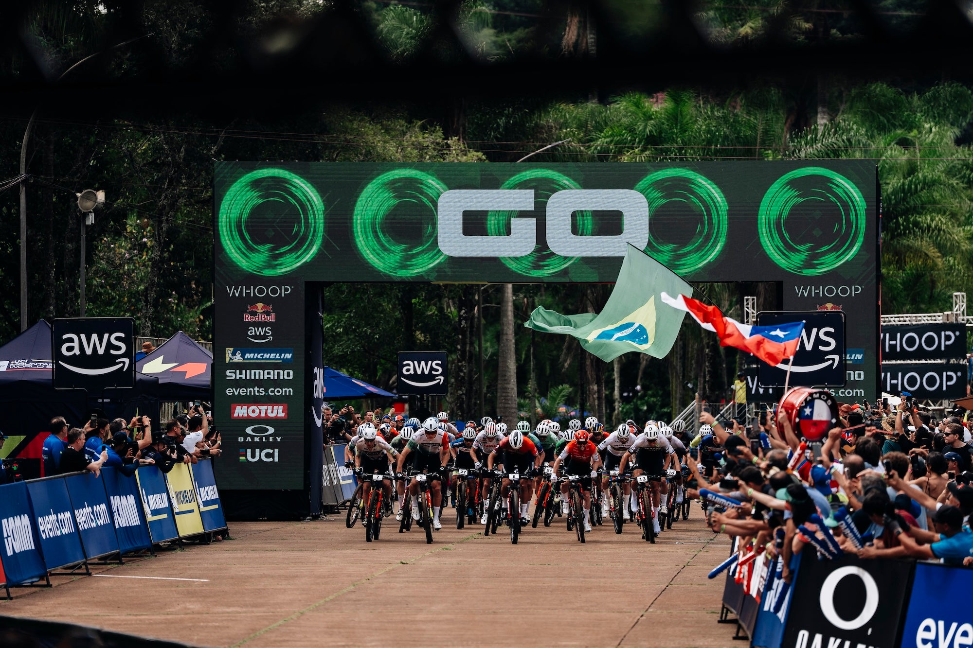 Cycling race starting line with riders and spectators at a professional event in Brazil