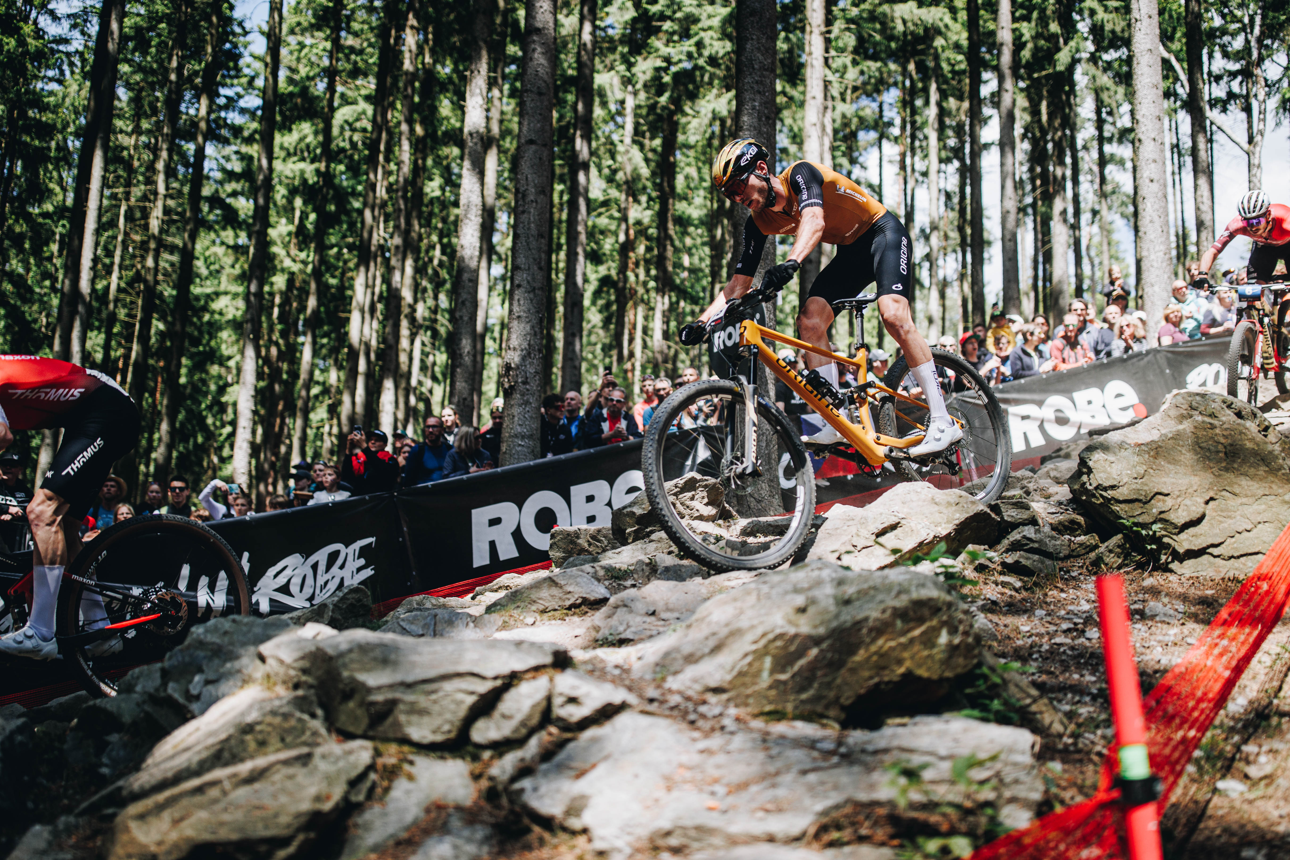 TRP Biker riding a mountain bike on rocky terrain with a crowd in Nove mesto